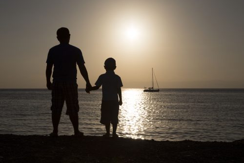 Fater and son fathers day son boat on the lake with the sun set