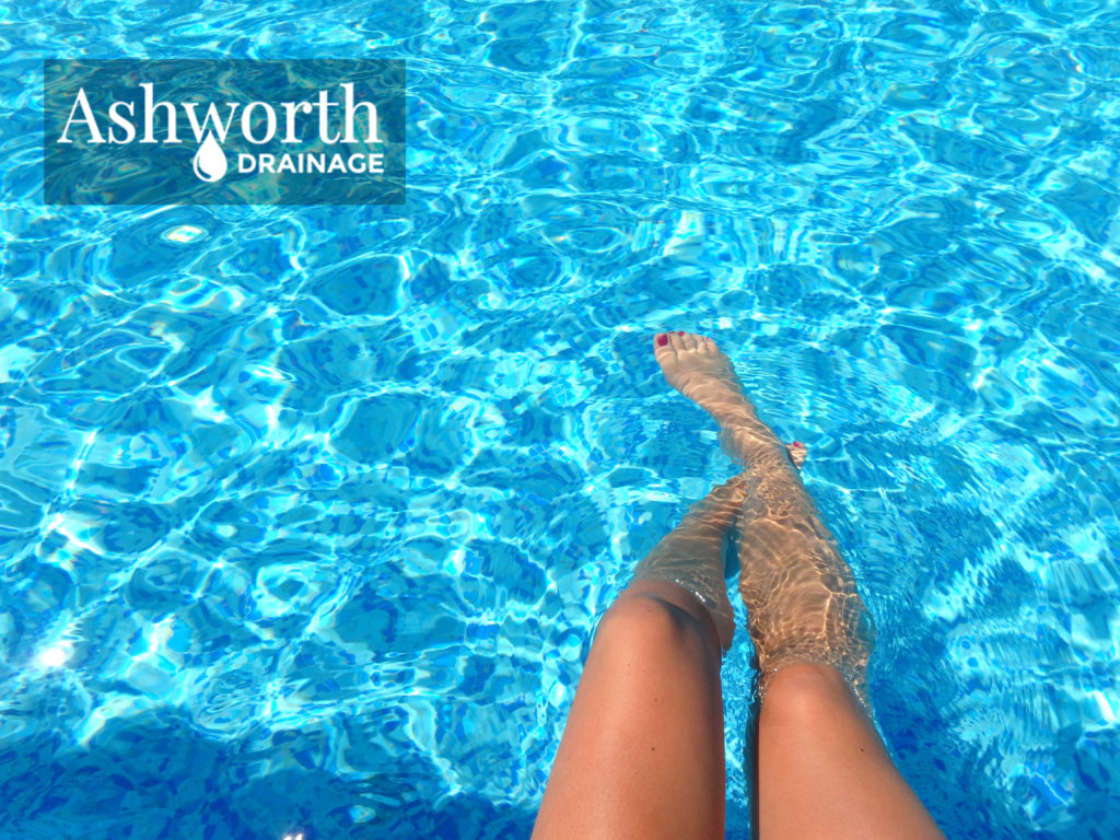 Ashworth drainage logo, woman's legs in clear blue pool water