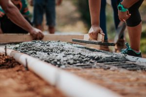 Professionals lay down fresh concrete